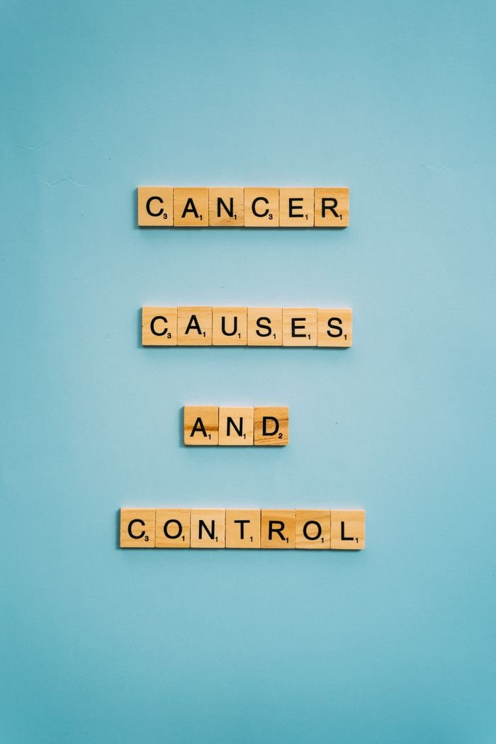 Scrabble tiles on blue background spelling 'Cancer Causes and Control' for awareness.